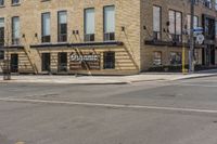 an empty street in front of a brick building with stairs and signage for dynamite pizza