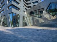 a person walking near a building with large windows and a concrete block floor in the middle