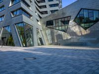 a person walking near a building with large windows and a concrete block floor in the middle