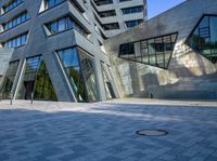 a person walking near a building with large windows and a concrete block floor in the middle