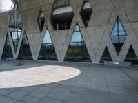 a walkway and parking lot covered with stone blocks and windows in front of an open space