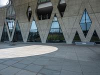 a walkway and parking lot covered with stone blocks and windows in front of an open space