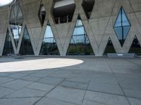 a walkway and parking lot covered with stone blocks and windows in front of an open space