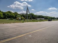 an empty runway and construction equipment on the side of the road in a suburban area