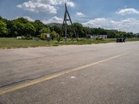 an empty runway and construction equipment on the side of the road in a suburban area