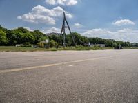 an empty runway and construction equipment on the side of the road in a suburban area