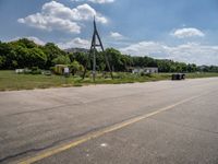 an empty runway and construction equipment on the side of the road in a suburban area