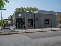 a store on the corner in a small town that has lots of gray brick walls