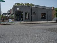 a store on the corner in a small town that has lots of gray brick walls