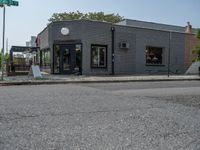 a store on the corner in a small town that has lots of gray brick walls