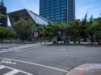 street intersection with a traffic light, trees and an airport building in the background on a sunny day