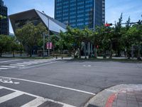 street intersection with a traffic light, trees and an airport building in the background on a sunny day