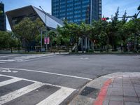 street intersection with a traffic light, trees and an airport building in the background on a sunny day