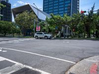 street intersection with a traffic light, trees and an airport building in the background on a sunny day