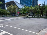 street intersection with a traffic light, trees and an airport building in the background on a sunny day