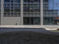 this street is paved and graveled up in front of a building with many windows