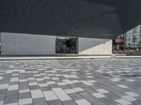 a white building next to a pool in a courtyard area with a walkway leading into it