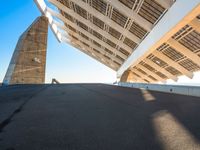 the underside of a roof of a building against a sky background and with sun shining on it