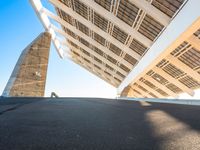 the underside of a roof of a building against a sky background and with sun shining on it