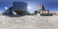 the building has many windows with circular glass fronts around it, as a camera lens makes its way to the ground in an optically view