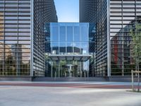 a big tall glass building with a parking lot behind it in front of it a bench