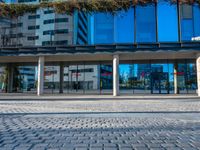 a brick floor with large columns stands out in front of a building on a sunny day