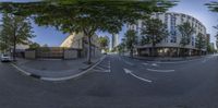 a street with trees and buildings at the end of it and a curved road passing through