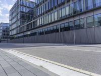 an empty paved street and a building on the other side of the road, which appears to be a square