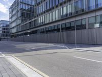 an empty paved street and a building on the other side of the road, which appears to be a square