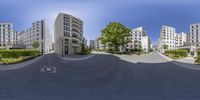 a view from inside a fish eye lens of several apartment buildings and trees in front