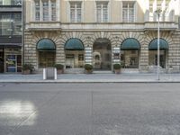 a building with arched windows is in front of the street in front of some buildings