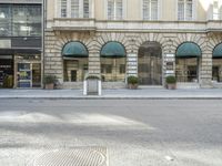 a building with arched windows is in front of the street in front of some buildings