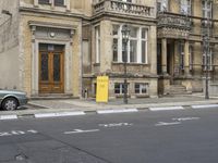 an empty building with signs on the street and people on bikes in traffic passing by