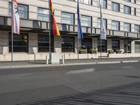 a bus is on the street next to many flags in front of a building on the road