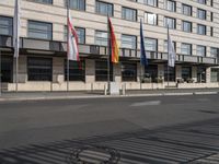 a bus is on the street next to many flags in front of a building on the road