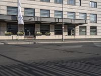 a bus is on the street next to many flags in front of a building on the road