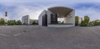 a distorted image of the entrance to an office building with the road around it and buildings in the background