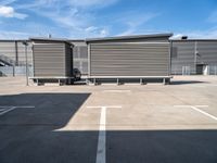 two wooden benches sit side by side in a parking lot outside of a building with stairs and a ramp on each side