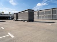 two wooden benches sit side by side in a parking lot outside of a building with stairs and a ramp on each side