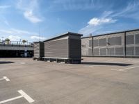 two wooden benches sit side by side in a parking lot outside of a building with stairs and a ramp on each side