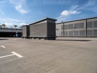 two wooden benches sit side by side in a parking lot outside of a building with stairs and a ramp on each side