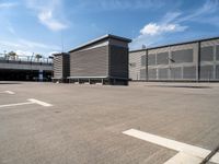 two wooden benches sit side by side in a parking lot outside of a building with stairs and a ramp on each side