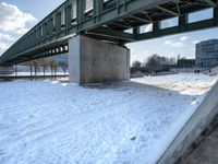 there is a snow covered ground with some stairs in front of it in the background, on which one can be seen a concrete structure and a long bridge