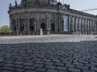 a man riding a skateboard on a brick road in front of a large building