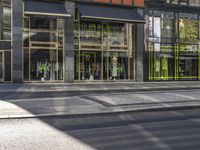 a traffic light with some pedestrians out side of it near a building in the city