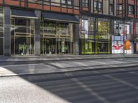 a traffic light with some pedestrians out side of it near a building in the city