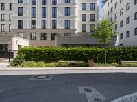 a bench at the street side, with buildings in the background at the end of a street