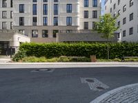 a bench at the street side, with buildings in the background at the end of a street