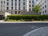 a bench at the street side, with buildings in the background at the end of a street