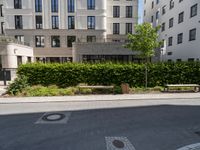 a bench at the street side, with buildings in the background at the end of a street